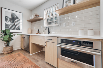 a kitchen with wooden cabinets and white countertops at Caveness Farms Apartments, North Carolina, 27587